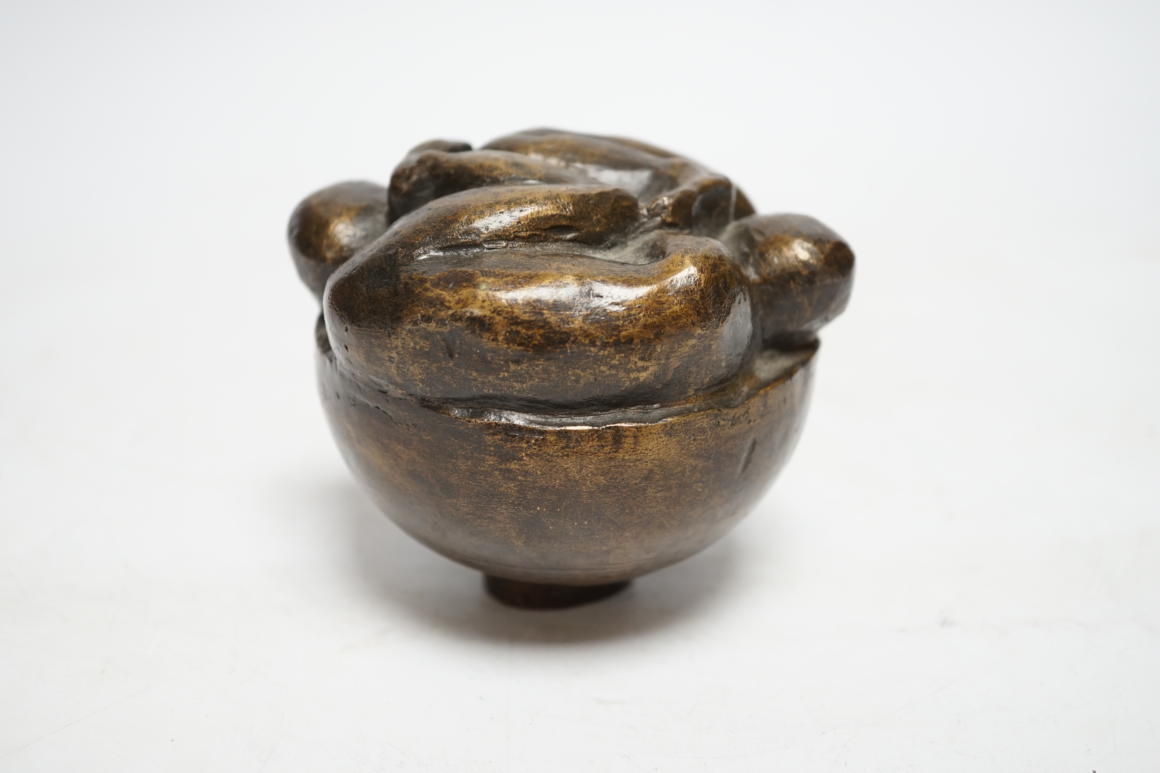 A squat bronze paper weight, the top of two intertwined figures, 8cm high
